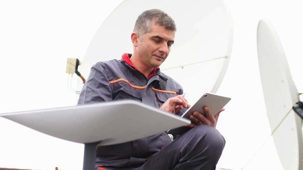 A man shown installing a satellite dish