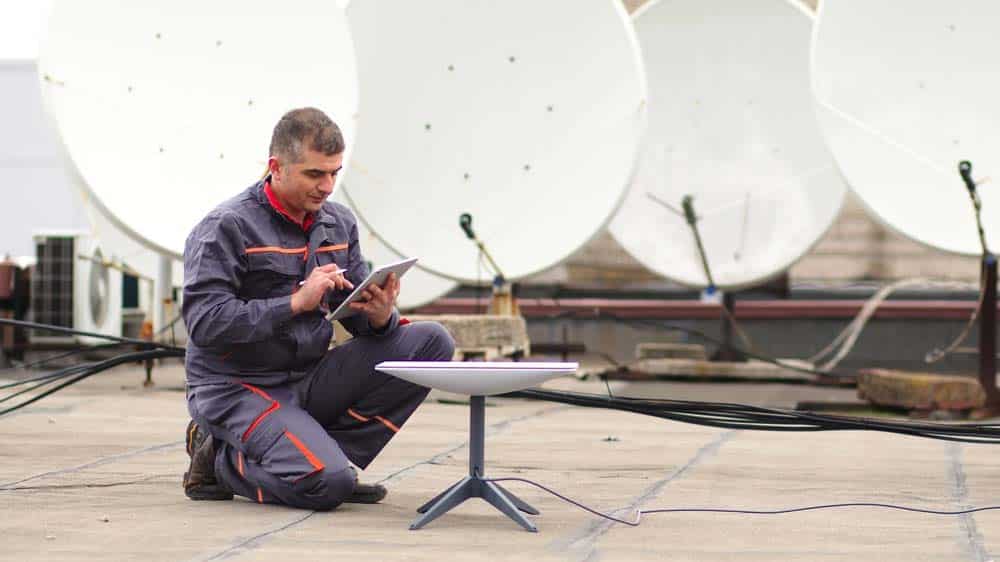 A man installs a satellite dish